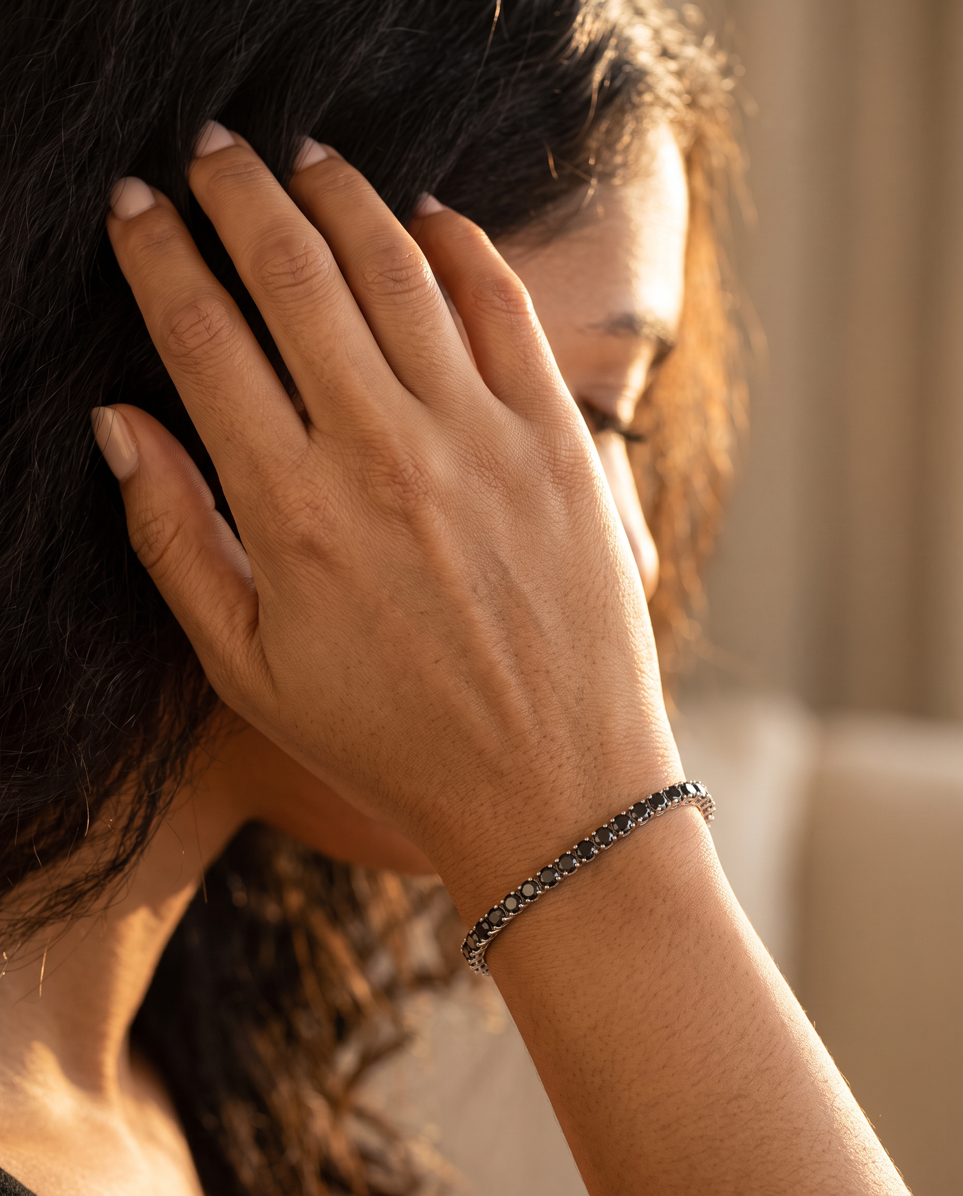 Pulsera negra, mano en el pelo